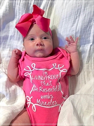 Amanda Rodgers tubal reversal baby has a custom onesie that says she is a miracle