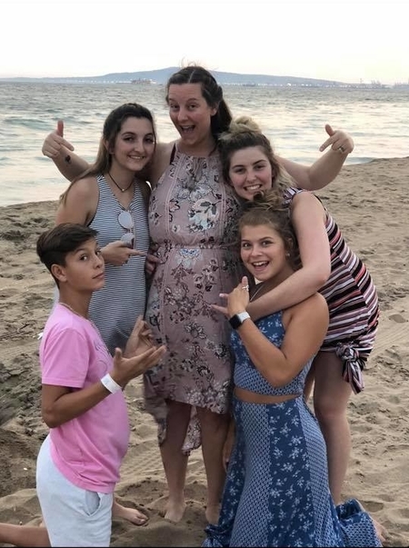 jamie jackson poses with her older kids at the seashore to show off her pregnanacy