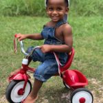 tubal reversal baby of bathsheba shelton of houston is now 2 and sitting on a red tricycle wearing overalls