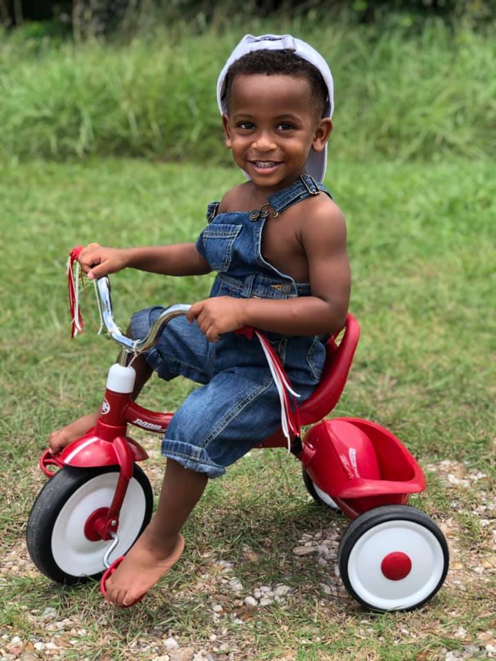 tubal reversal baby of bathsheba shelton of houston is now 2 and sitting on a red tricycle wearing overalls