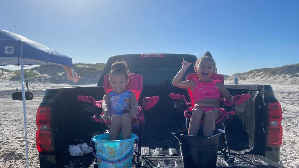2 growing kids who were tubal reversal babies sitting in a pickup truck bed