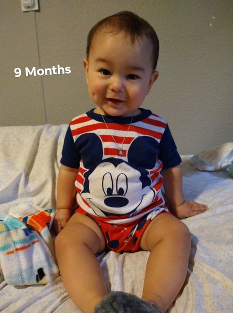daniela arthur's first tubal reversal baby at 9 months wearing a mickey mouse onesie