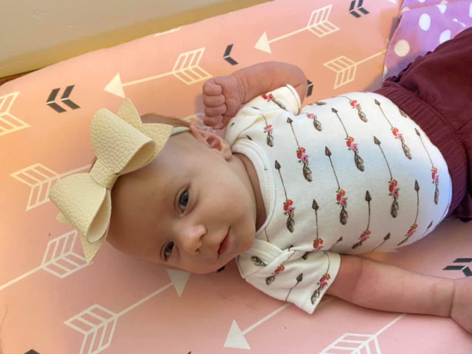 sarah moyer's tr baby girl with a yellow bow on her head
