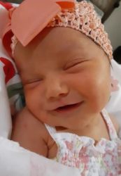 heather modesto's 5th tubal reversal baby girl in a pink knitted cap with bow