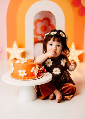 connie hyles tubal reversal baby turned 1 wearing a flower child outfit eathing a flower power cake